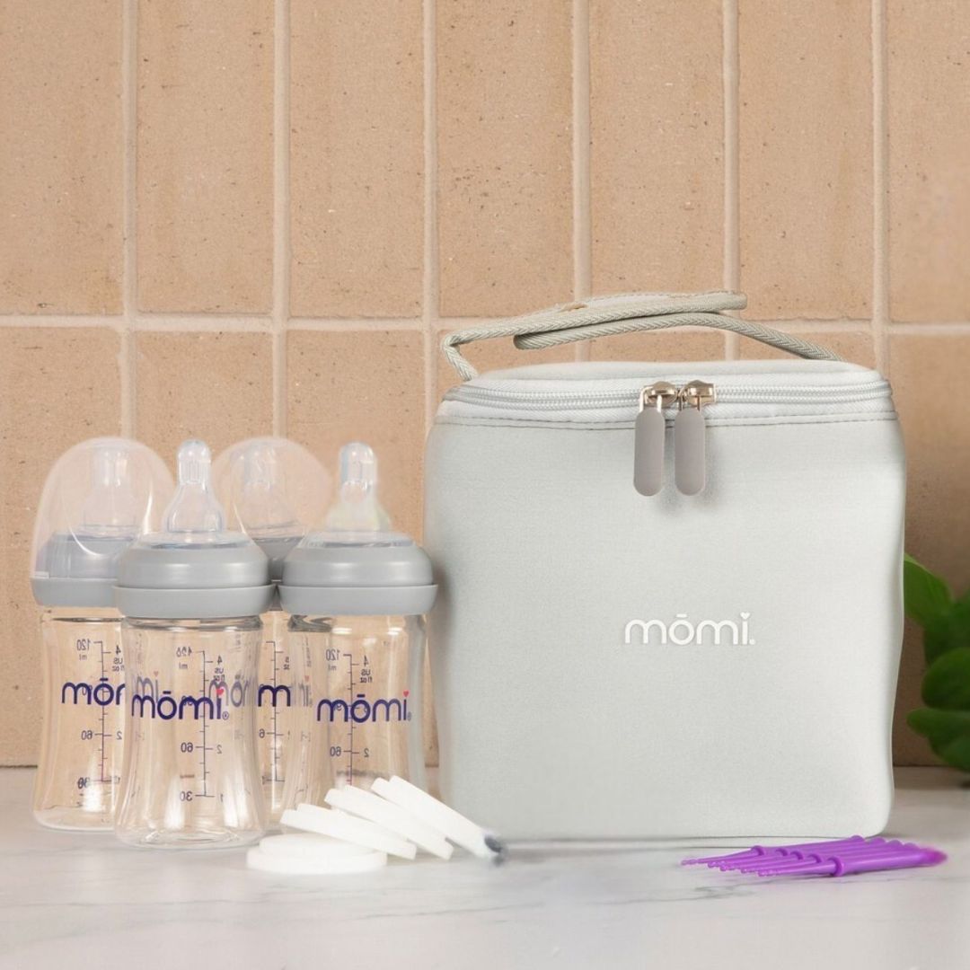 mōmi breast-like bottle set with gray collars, gray milk cooler bag, milk storage discs and cleaning tools ready for feeding baby on-the-go