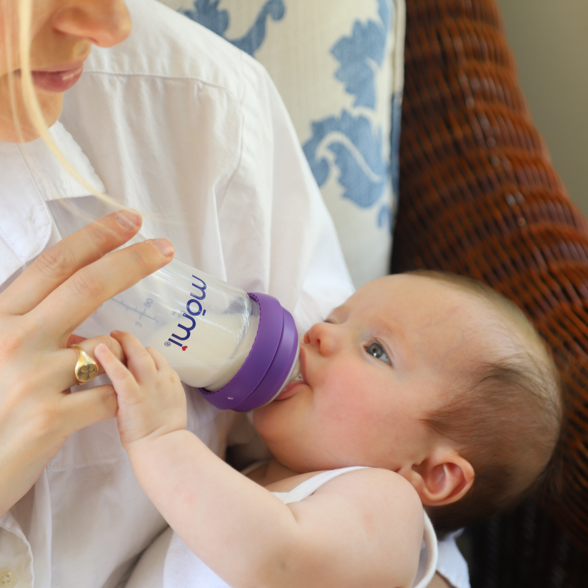 Mom feeding baby with mōmi’s breast-like bottle, recommended for breastfeeding support